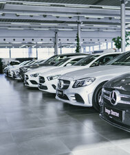 Reihe von Mercedes-Benz Fahrzeugen in einem Ausstellungsraum.
