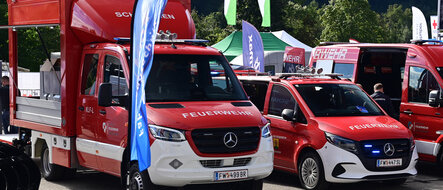 Drei rote Mercedes-Benz Feuerwehrfahrzeuge ausgestellt auf der Retter Messe.