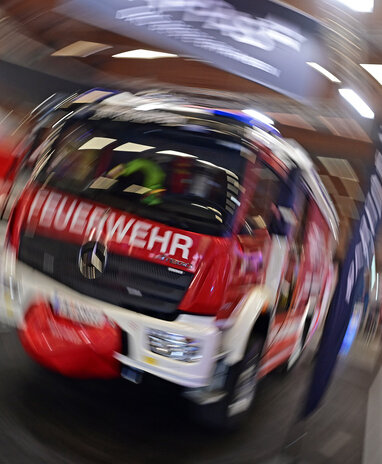 Ein Mercedes-Benz Feuerwehrfahrzeug auf der Retter Messe, unscharf abgebildet.