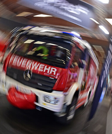 Ein Mercedes-Benz Feuerwehrfahrzeug auf der Retter Messe, unscharf abgebildet.