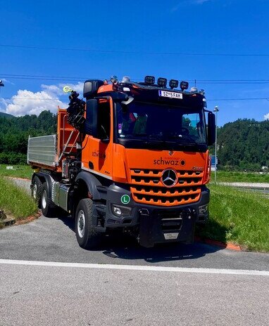 Orangefarbener Mercedes-Benz Arocs der Silberstadt Schwaz mit einem Kipperaufbau.