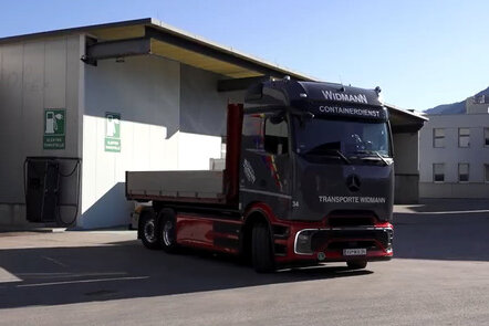 Der elektrische Lkw eActros von Mercedes-Benz aus dem Fuhrpark der Firma Widmann steht vor einer Ladestation.