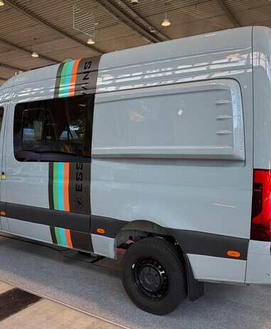 Grauer Camper-Van mit Streifen und 'Pappas' Logo auf Messe.
