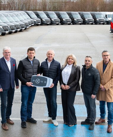 Übergabe von Mercedes-Benz Fahrzeugen an eine Gruppe von Personen.