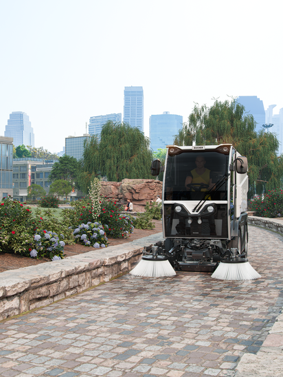 Bucher Municipal CityCat VR17e reinigt einen gepflasterten Parkweg.