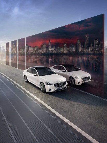 Eine weiße Mercedes-AMG Limousinen spiegelt sich an einer Wand. | © Mercedes-Benz Group