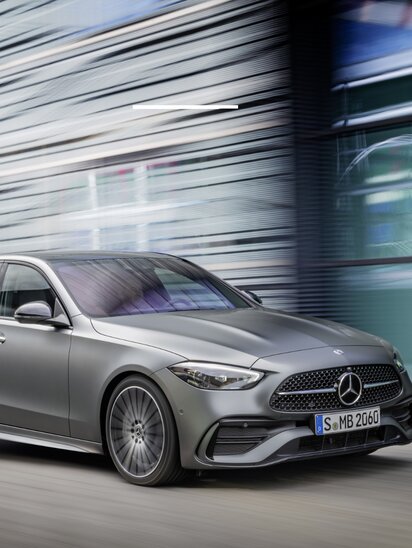 Eine graue Mercedes-Benz C-Klasse Limousine fährt dynamisch.