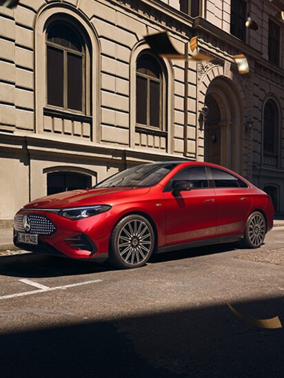 Ein roter Mercedes-Benz CLA mit EQ-Technologie parkt in einer städtischen Umgebung.