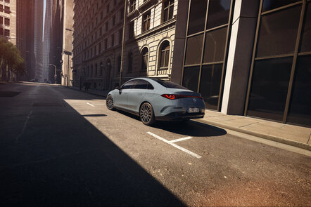 Mercedes-Benz CLA Limousine parkt in einer sonnigen Straßenszene einer Stadt.