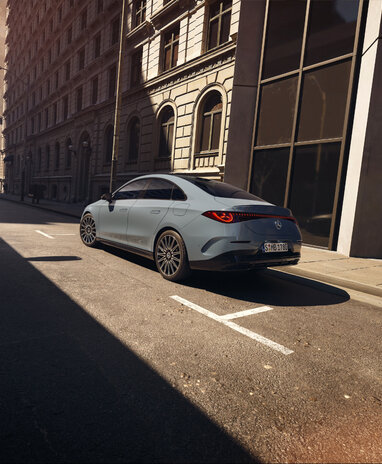 Mercedes-Benz CLA Limousine parkt in einer sonnigen Straßenszene einer Stadt.