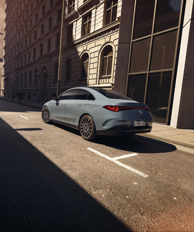 Mercedes-Benz CLA Limousine parkt in einer sonnigen Straßenszene einer Stadt.