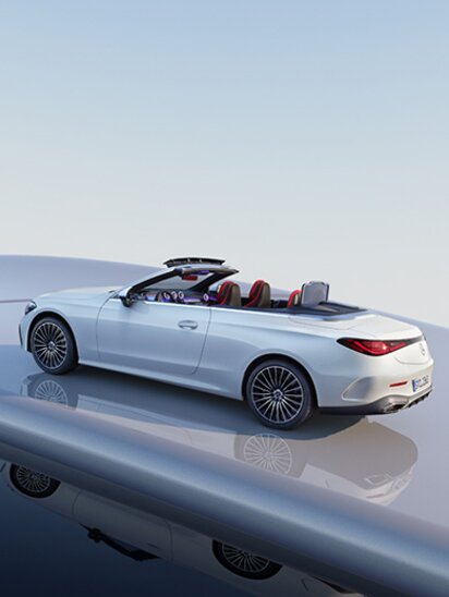 Weißes Mercedes-Benz CLE Cabrio mit offenem Verdeck auf glänzender Oberfläche.