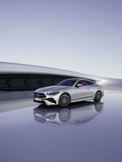 Ein silbernes Mercedes-Benz CLE Coupé steht auf einem spiegelnden Boden vor moderner Architektur. | © Mercedes-Benz Group AG