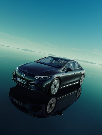 Ein Mercedes-Benz EQE mit schwarzer Lackierung fährt auf einer spiegelglatten Oberfläche, die den Himmel reflektiert. | © Mercedes-Benz Group AG