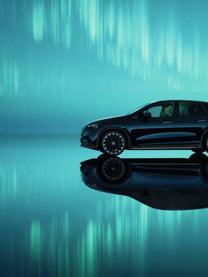 Ein Mercedes-Benz EQE SUV spiegelt sich auf einer glatten Oberfläche unter Polarlichtern. | © Mercedes-Benz AG