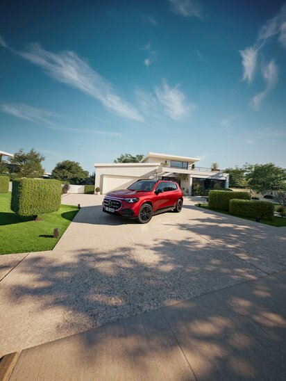 Ein roter Mercedes-Benz GLB steht vor einem modernen Haus in einer Einfahrt. | © Mercedes-Benz AG