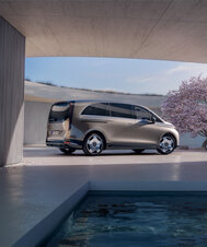 Ein Mercedes-Benz VLE steht neben einem modernen Gebäude und einem blühenden Baum. | © Mercedes-Benz AG
