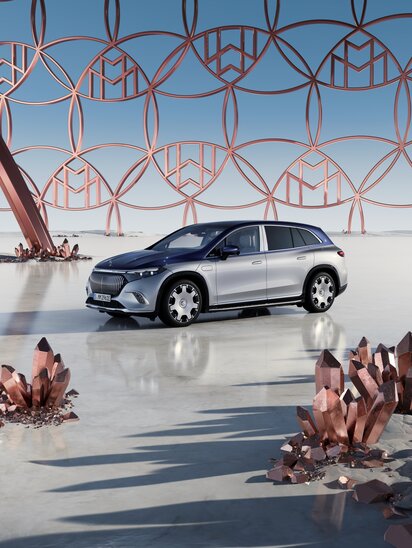 Ein Mercedes-Maybach EQS SUV steht auf einer futuristischen Fläche mit Kristallen und geometrischen Strukturen im Hintergrund. | © Mercedes-Benz AG
