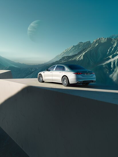 Eine silberne Mercedes-Maybach S-Klasse auf einer Plattform vor surrealer Berglandschaft mit einem Planeten im Hintergrund. | © Mercedes-Benz AG